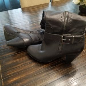 Black boots with stitching on the side and buckle.